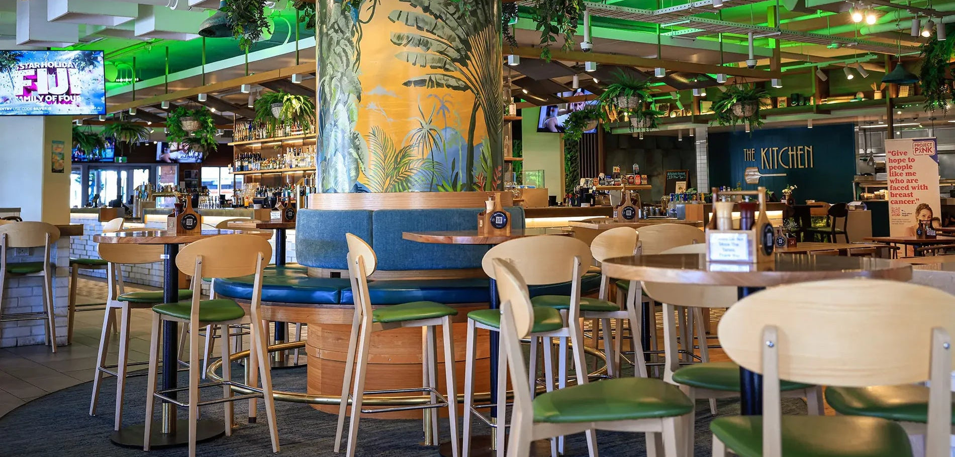 Interior of a restaurant with green and white decor, including tables and chairs.